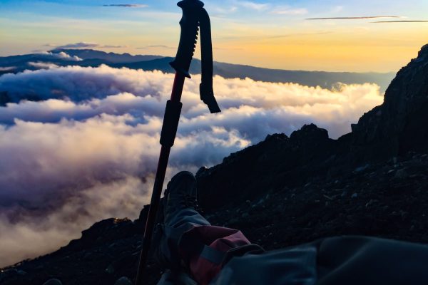 low-section-person-by-hiking-pole-mountain-against-sky-sunset